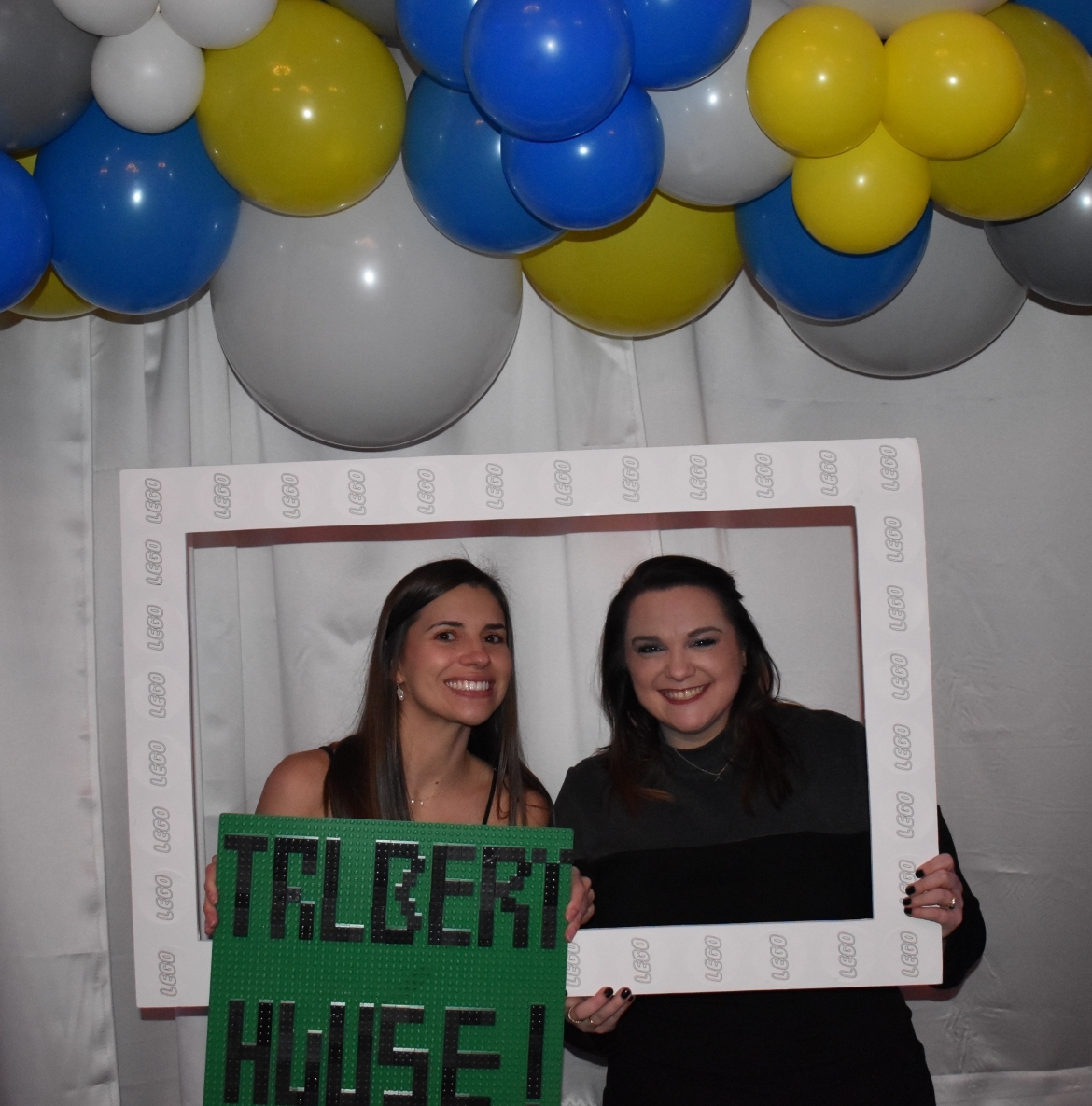 Two people holding picture frame and Talbert House sign